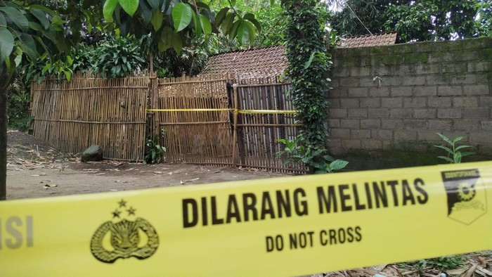 Warga melihat rumah sekeluarga di Kediri yang tewas bersimbah darah dan sudah dipasangi garis polisi.