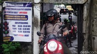 Pengendara sepeda motor mengantre untuk melintas melalui pintu kecil di kawasan Taman Tekno, Tangerang Selatan, Banten, Jumat (6/12/2024).