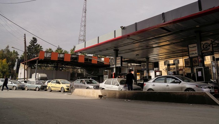 People queue as they wait to fuel up at a gas station, after rebels took the main northern city of Aleppo and have since pushed south from their enclave in northwest Syria, December 4, 2024. REUTERS/Karam al-Masri