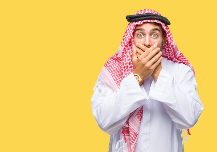 Young handsome man wearing keffiyeh over isolated background shocked covering mouth with hands for mistake. Secret concept.