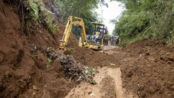Pembersihan jalur terdampak longsor di Cianjur Pengendara sepeda motor menunggu petugas membersihkan jalan utama yang dipenuhi lumpur akibat tanah longsor di Sukanagara, Kabupaten Cianjur, Jawa Barat, Jumat (6/12/2024). Akses jalan utama penghubung Kecamatan Sukanagara dengan Kecamatan Kadupandak, Kabupaten Cianjur tersebut mulai bisa dilewati kendaraan yang sebelumnya sempat terputus selama tiga hari akibat tertimbun longsor. ANTARA FOTO/Novrian Arbi/nym.