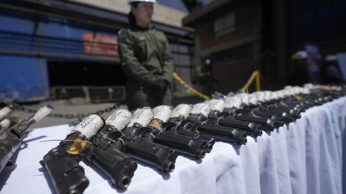 Polisi Kolombia Leburkan 23 Ribu Senjata Sitaan Jadi Bahan Konstruksi A police stands guard over seized weapons to be destroyed at a metallurgic plant in Nobsa, Colombia, Thursday, Dec. 5, 2024. (AP Photo/Fernando Vergara)