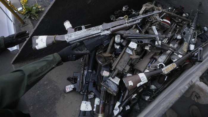 Polisi Kolombia Leburkan 23 Ribu Senjata Sitaan Jadi Bahan Konstruksi A police stands guard over seized weapons to be destroyed at a metallurgic plant in Nobsa, Colombia, Thursday, Dec. 5, 2024. (AP Photo/Fernando Vergara)
