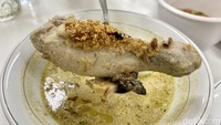 Seporsi Opor Susu Ayam legendaris dilengkapi dengan satu potong daging ayam opor bagian paha bawah. Ditambah telur rebus, bawang goreng dan perasan jeruk limo. Foto: detikFood