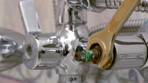 replacing defective ceramic disc cartridge covered with limescale in shower mixer using wrench