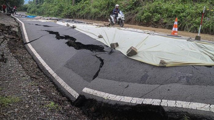 Jalan terbelah di Pelabuhan Ratu Sukabumi Warga melihat jalan yang terbelah akibat longsor di Pelabuhan Ratu, Kabupaten Sukabumi, Jawa Barat, Sabtu (7/12/2024). Pergerakan tanah disebabkan oleh tingginya intesitas hujan di kawasan tersebut, mengakibatkan akses jalan menuju tempat wisata tidak bisa dilintasi oleh kendaraan roda empat. ANTARA FOTO/Yulius Satria Wijaya/aww.