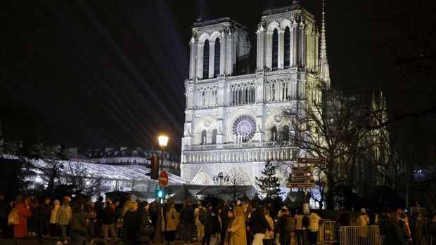 Crowds gather in front of Notre-Dame de Paris cathedral, on the eve of its official reopening after more than five-years of reconstruction work following the April 2019 fire, in Paris on December 6, 2024. Notre-Dame Cathedral is set to re-open early December 2024, with a weekend of ceremonies on December 7 and 8, 2024, five years after the 2019 fire which ravaged the world heritage landmark and toppled its spire. Some 250 companies and hundreds of experts were mobilised for the five-year restoration costing hundreds of millions of euros. (Photo by Ludovic MARIN / AFP)