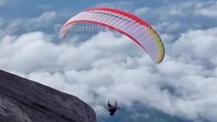 Pendaki, diduga WNA, menggunakan paralayang saat turun dari puncak Gunung Agung, Karangasem, Bali. (Tangkapan layar video viral)