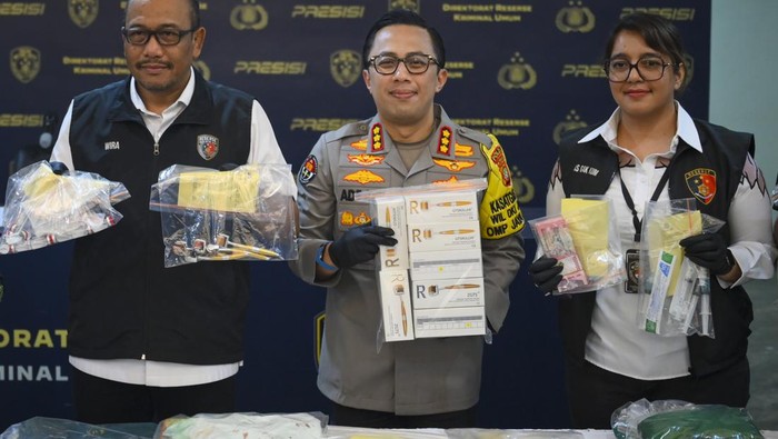 Petugas menggiring tersangka saat konferensi pers kasus praktik kecantikan ilegal di Polda Metro Jaya, Jakarta, Jumat (6/12/2024). Subdit Renakta Ditreskrimum Polda Metro Jaya berhasil membongkar praktik klinik kecantikan ilegal dan produksi alat kesehatan tidak sesuai standar serta menangkap dua tersangka yang menawarkan layanan penghilang bopeng wajah menggunakan alat bernama GTS Roller. ANTARA FOTO/Muhammad Ramdan/nym.