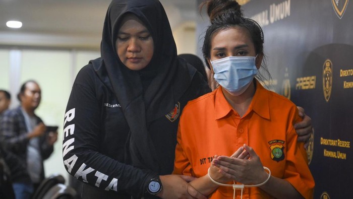 Potret Dokter Kecantikan Abal-abal βRia Beautyβ Berbaju Tahanan Petugas menggiring tersangka saat konferensi pers kasus praktik kecantikan ilegal di Polda Metro Jaya, Jakarta, Jumat (6/12/2024). Subdit Renakta Ditreskrimum Polda Metro Jaya berhasil membongkar praktik klinik kecantikan ilegal dan produksi alat kesehatan tidak sesuai standar serta menangkap dua tersangka yang menawarkan layanan penghilang bopeng wajah menggunakan alat bernama GTS Roller. ANTARA FOTO/Muhammad Ramdan/nym.