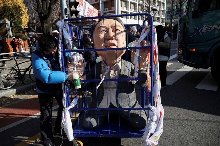 A protestor stands next to an effigy of South Korean President Yoon Suk Yeol as they take part in a rally calling for the impeachment of Yeol, who declared martial law, which was reversed hours later, in front of the National Assembly in Seoul, South Korea, December 7, 2024. REUTERS/Kim Hong-ji TPX IMAGES OF THE DAY