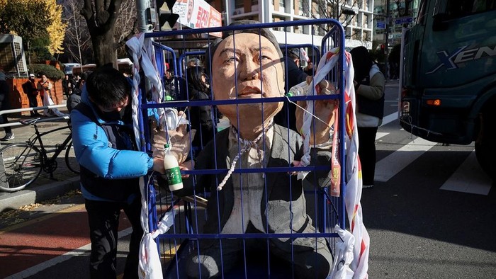 A protestor stands next to an effigy of South Korean President Yoon Suk Yeol as they take part in a rally calling for the impeachment of Yeol, who declared martial law, which was reversed hours later, in front of the National Assembly in Seoul, South Korea, December 7, 2024. REUTERS/Kim Hong-ji TPX IMAGES OF THE DAY
