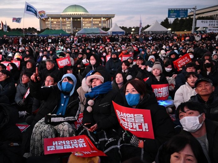 People take part in a protest calling for the ouster of South Korea President Yoon Suk Yeol outside the National Assembly in Seoul on December 7, 2024. Nearly 150,000 people attended a rally outside South Koreas parliament on December 7, Yonhap reported, demanding Yoon step down as lawmakers inside struggled to muster the votes to impeach him. (Photo by JUNG Yeon-je / AFP)