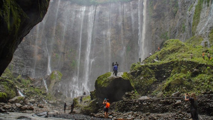 Wisatawan mengunjungi air terjun Tumpak Sewu di Ampelgading, Kabupaten Malang, Jawa Timur, Sabtu (7/12/2024). Kementerian Pariwisata dan Ekonomi Kreatif (Kemenparekraf) akan memperkuat kampanye Bangga Berwisata di Indonesia (BBWI) serta mendorong pemerintah daerah bersama industri dan pihak lainnya agar aktif berinovasi dalam membuat paket wisata untuk mengejar target pergerakan wisatawan nasional di 2025 yang mencapai 1,08 miliar wisatawan nusantara dan 17 juta-18 juta wisatawan mancanegara di 2025 dengan kontribusi terhadap PDB mencapai 4,6 persen hingga devisa pariwisata mencapai 22,1-25,2 miliar dolar AS. ANTARA FOTO/Irfan Sumanjaya/nz