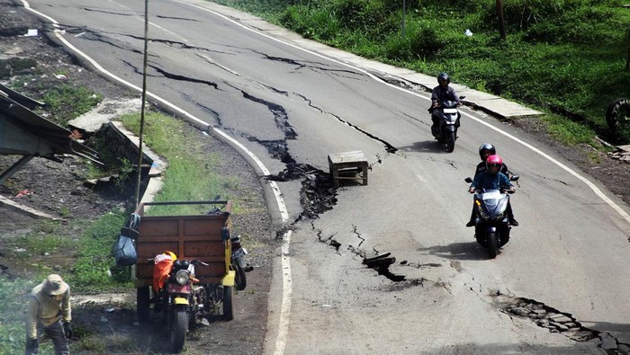 Pengendara motor melewati jalan retak dan amblas di Jalan Raya Baros - Sigaranten, Kabupaten Sukabumi, Jawa Barat, Minggu (8/12/2024). Pergerakan tanah akibat hujan terus menerus tersebut menyebabkan jalan retak dan amblas sehingga berpotensi menyebabkan kecelakaan. ANTARA FOTO/Yulius Satria Wijaya/rwa.