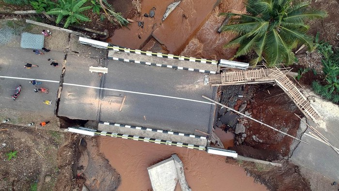 Foto udara jembatan jalur wisata Pelabuhan Ratu - Geopark Ciletuh terputus di Kabupaten Sukabumi, Jawa Barat, Sabtu (7/12/2024). Hujan ekstrem dengan intensitas tinggi dan berdurasi lama yang melanda Kabupaten Sukabumi pada Rabu (5/12), membuat Sungai Cisantri meluap dan mengakibatkan terputusnya jembatan akses wisata menuju Geopark Ciletuh. ANTARA FOTO/Yulius Satria Wijaya/aww.