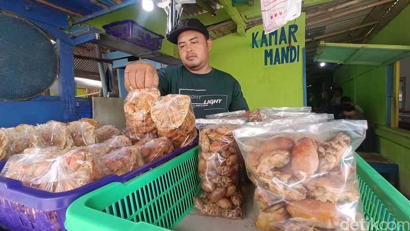 Agus menata peyek yutuk yang baru dimasak di lapaknya sekitar Pantai Widarapayung, Kabupaten Cilacap, Minggu (8/12/2024).