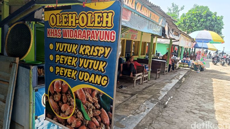 Agus menata peyek yutuk yang baru dimasak di lapaknya sekitar Pantai Widarapayung, Kabupaten Cilacap, Minggu (8/12/2024).