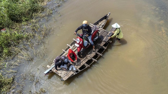 Mengais Rezeki di Tengah Banjir Jambi Banjir merendam Jalan Lintas Jambi-Berbak, Jambi. Banjir yang terjadi sejak seminggu terakhir itu dimanfaatkan warga untuk membuka jasa penyeberangan motor.
