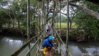 Warga secara swadaya membuat jembatan darurat yang menghubungkan Desa Cariu dengan Desa Bobojong, Cidolog, Sukabumi, Jawa Barat, Minggu (8/12/2024).
