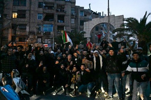 Local residents cheer because the collect on a avenue within the Damascus suburb of Jaramana on December 8, 2024. Syrian rebels acknowledged on December 8 that President Bashar al-Assad had fled the nation, calling on citizens in a distant places nation to return to a 