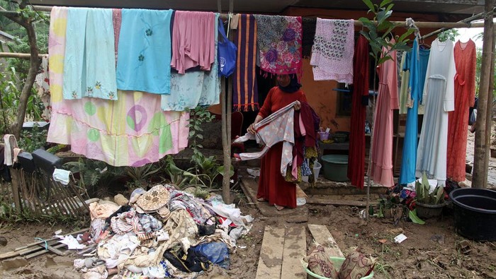 Warga menjemur pakaiannya pascabanjir bandang di Sigaranten, Kabupaten Sukabumi, Jawa Barat, Minggu (8/12/2024). Warga mulai membersihkan sisa lumpur dan barang rumah tangga pascabanjir bandang setinggi 2,5 meter yang menerjang wilayah tersebut. ANTARA FOTO/Yulius Satria Wijaya/rwa.
