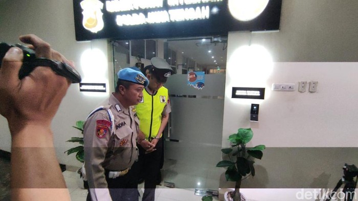 Aipda Robig mengenakan rompi hijau dengan tangan terborgol saat memasuki ruangan sidang etik di Mapolda Jateng, Senin (9/12/2024).