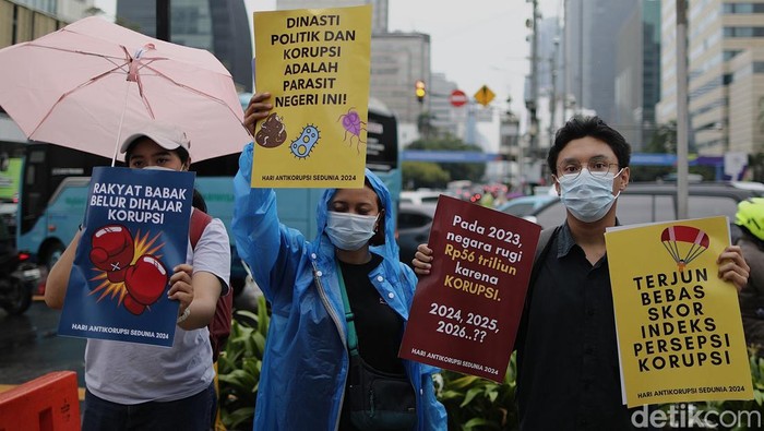 Para aktivis dari Indonesia Corruption Watch (ICW) memperingati hari antikorupsi sedunia dengan melakukan aksi simpatik di perempatan Sarinah, Jl MH Thamrin, Jakarta, Senin (9/12/2024). Tema aksi 'Bertahan Bersama di Titik Terendah Pemberantasan Korupsi, Demokrasi dan Krisis Iklim'. Aksi berlangsung tertib dengan cuaca gerimis.