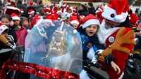 Sebuah tim yang terdiri dari 40 Santa mengunjungi lima sekolah dasar pada Jumat pagi (6/12). Sepeda motor mereka dipenuhi dengan karangan bunga yang berkedip-kedip dan perada yang berkilauan - dan beberapa anak bahkan dapat duduk di atasnya.  