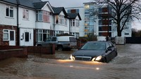 Sebuah mobil nekat menerobos banjir setinggi setengah ban di Hereford, Inggris.