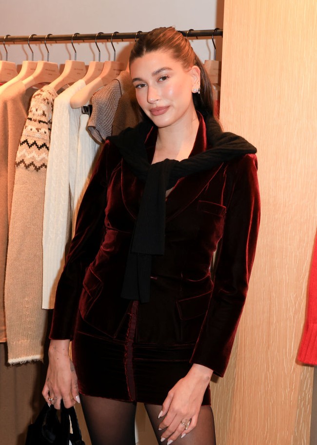 Hailey mengenakan rok dan jaket warna burgundy yang serasi. Dia melengkapi penampilannya dengan tas kecil dari Prada dan sepatu stiletto berwarna hitam.  Foto: WWD via Getty Images/River Callaway