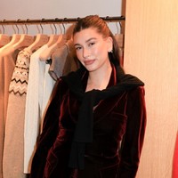 Hailey mengenakan rok dan jaket warna burgundy yang serasi. Dia melengkapi penampilannya dengan tas kecil dari Prada dan sepatu stiletto berwarna hitam.  Foto: WWD via Getty Images/River Callaway