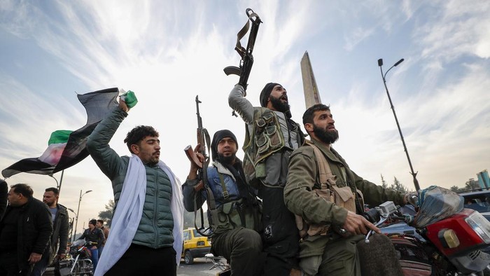 Syrian opposition fighters celebrate after the Syrian government collapsed in Damascus, Syria, Sunday, Dec. 8, 2024. (AP Photo/Omar Sanadiki)