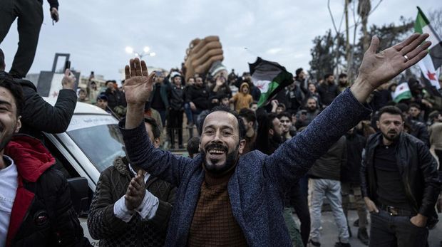 People gather to celebrate the fall of the Syrian government, in Manbij, Syria, Sunday, Dec. 8, 2024. (Ugur Yildirim/Dia Photo via AP)
