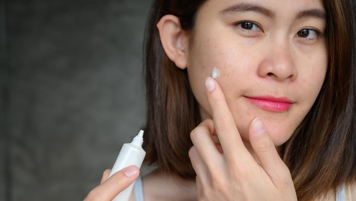 Ilustrasi wanita memakai obat jerawat