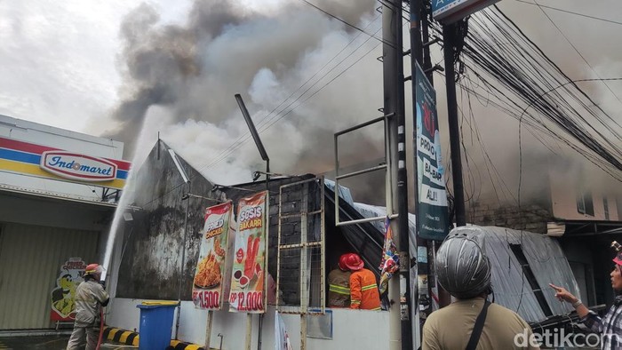 Petugas pemadam berupaya memadamkan api, Senin (9/12/2024).