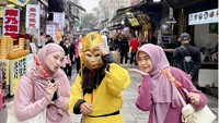 Suka dengan jajanan manis, Ricis tak melewatkan kesempatan jajan manisan buah sambil foto dengan karakter Sungokong. Foto: Instagram @riaricis1795