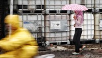 Sejumlah warga menerobos hujan di kawasan Cilincing, Jakarta Utara, Senin(9/12/2024).