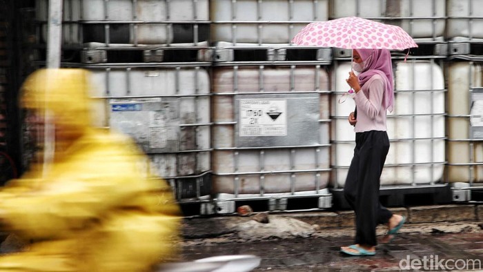 Sejumlah warga menerobos hujan di kawasan Cilincing, Jakarta Utara, Senin(9/12/2024). Badan Meteorologi, Klimatologi, dan Geofisika (BMKG) mengungkap adanya potensi cuaca ekstrem selama libur Natal 2024 dan Tahun Baru 2025 yang dipicu oleh sejumlah faktor di antaranya puncak musim hujan serta fenomena La Nina.