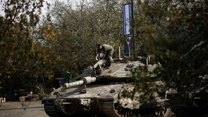Penampakan Tank-tank Israel di Perbatasan Suriah An Israeli soldier stands on a tank, near the ceasefire line between Syria and the Israeli-occupied Golan Heights, December 8, 2024. REUTERS/Shir Torem