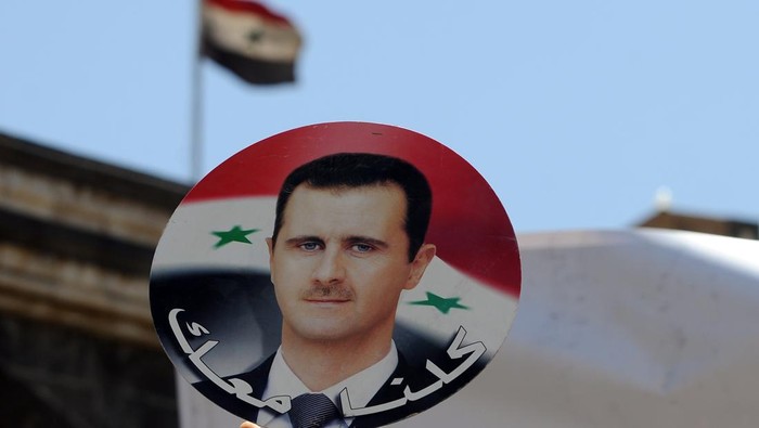 SANAA, YEMEN - APRIL 16: A Yemeni man holds a photo of Syrian President Bashar al-Assad during a protest against U.S. allied missile strikes against Syria outside the Syrian embassy on April 16, 2018 in Sanaa, Yemen. The U.S., Great Britain and France launched missile strikes in response to the Syrian goverment using chemical weapons against its own population. (Photo by Mohammed Hamoud/Getty Images)