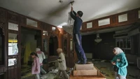Bagian dalamnya banyak barang-barang yang didominasi material kayu. Di dalam rumah juga menggunakan lampu gantung sehingga memberikan kesan mewah. Foto: Hussein Malla/AP via NPR