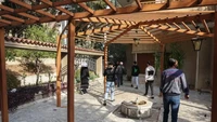Tampak orang-orang memasuki rumah al-Assad melalui taman. Foto: Omar Haj Kadour—AFP via Fortune