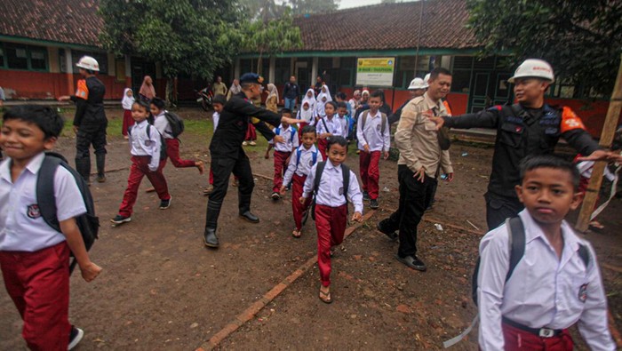 Siswa SDB Tegalpanjang 1 yang terdampak bencana di Desa Sukamaju, Cikembar, Kabupaten Sukabumi, Jawa Barat, Senin (9/12/2024), dijemput truk milik SAR Polisi Brimob. SAR Brimob memberikan pelayanan antar jemput kepada anak sekolah warga yang terdampak pergeseran tanah. 
ANTARA FOTO/Yulius Satria Wijaya