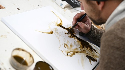 The Bavarian artist Werner Haertl paints with cow dung in his atelier in Reichersbeuern, Germany, December 4, 2024. REUTERS/Angelika Warmuth