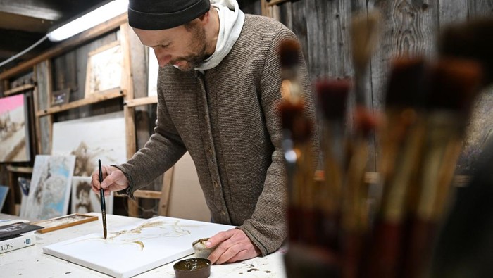 The Bavarian artist Werner Haertl paints with cow dung in his atelier in Reichersbeuern, Germany, December 4, 2024. REUTERS/Angelika Warmuth