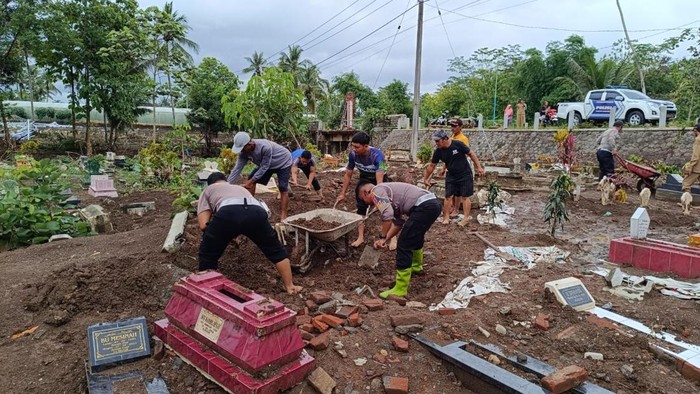 Warga bersama polisi bersihkan TPU yang rusak imbas banjir bandang di Blitar.