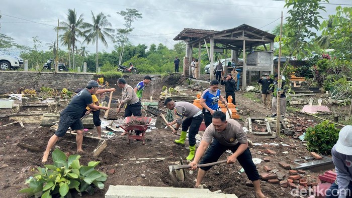 Warga - Polisi Bersihkan Makam Rusak Akibat Banjir Blitar