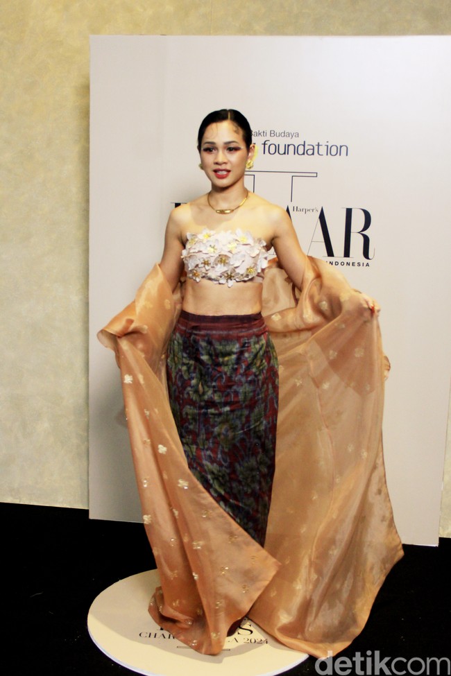 Andien bersolek dengan three-piece dress yang terdiri dari luaran panjang yang menyerupai kebaya panjang, crop top berhiaskan kelopak bunga tiga dimensi, dan rok tenun. Semuanya dirancang oleh Didiet Maulana. (Foto: Mohammad Abduh/detikcom)