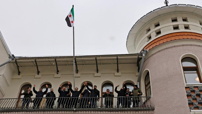 Bendera Oposisi Berkibar di Kedubes Suriah di Rusia People who introduced themselves as members of the Syrian diaspora pose with the Syrian opposition flag outside the Embassy of Syria in Moscow, Russia December 9, 2024. REUTERS/Yulia Morozova